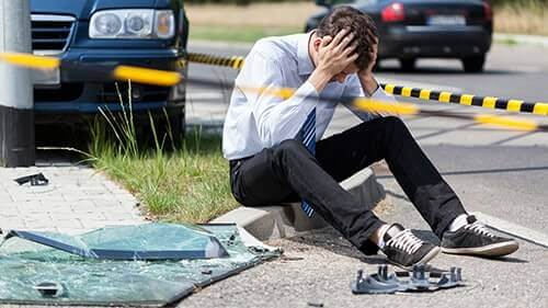 man-injured-scene-car-accident-looking-cell-phone